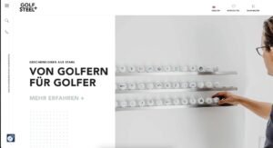 - Aktuelle Neuigkeiten in unserem Blog 23 Die Hand einer Person greift nach einem Golfball aus zwei an der Wand befestigten Regalen, die mehrere Golfbälle enthalten. Der Text auf der linken Seite lautet: Von Golfern für Golfer. Entdecken Sie eine besondere Website - mit dem Golf Steel+ Logo oben.